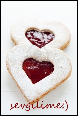 6259015-two-linzer-cookies-with-heart-shape-raspberry-jam-window-on-white-wood